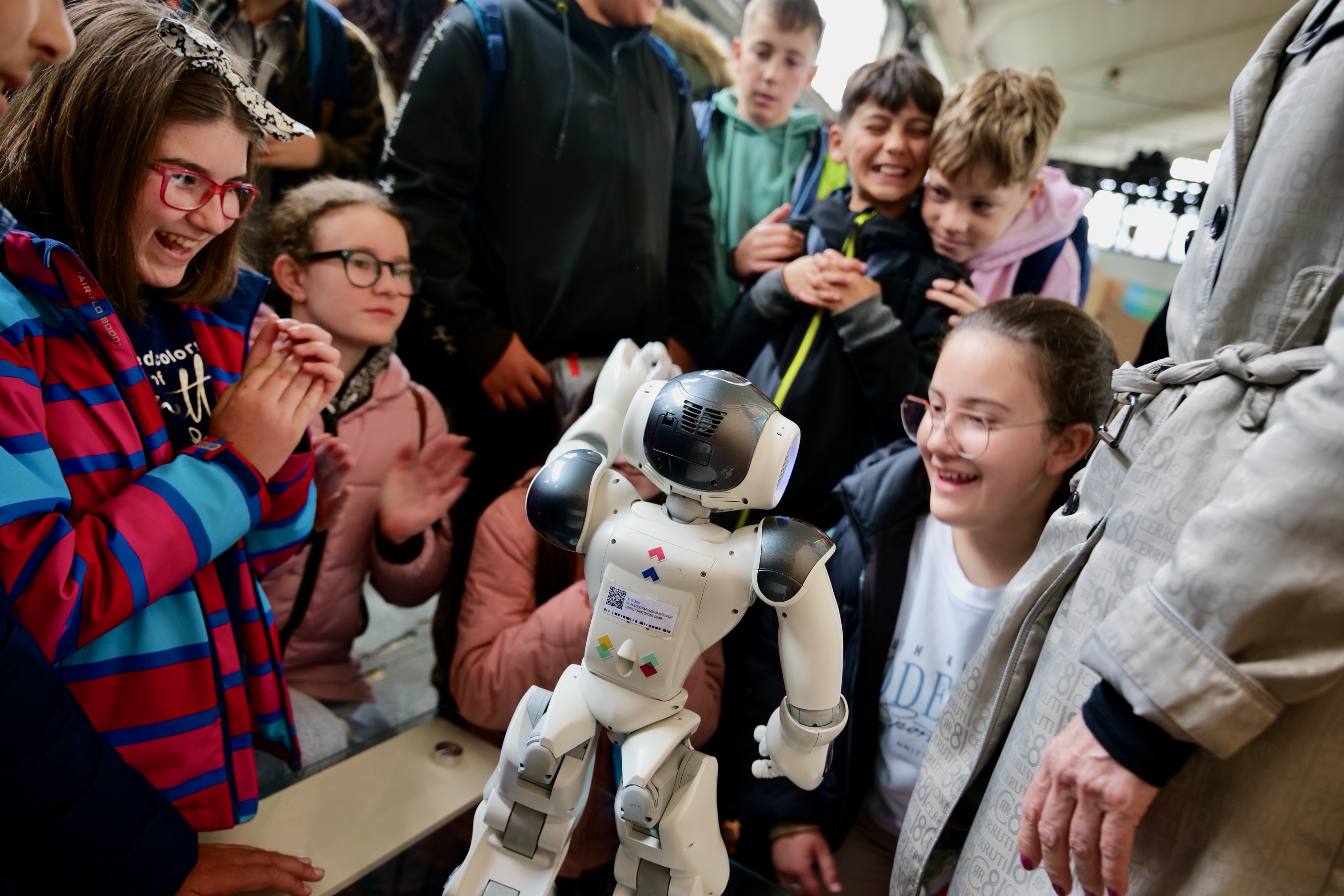 Niñas y niños entusiasmados interactualdo con NAO Niñas y niños entusiasmados interactualdo con NAO